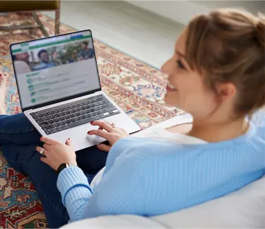Kristen, a real person living with narcolepsy, sitting with her laptop