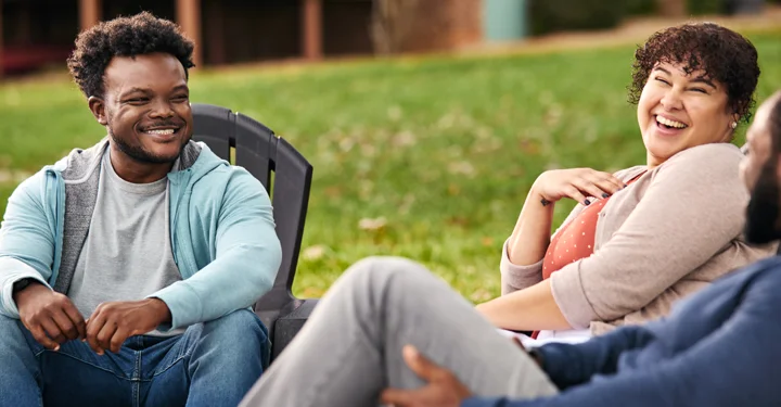 Chris, a real person with narcolepsy with
cataplexy taking WAKIX, sitting with friends
outdoors